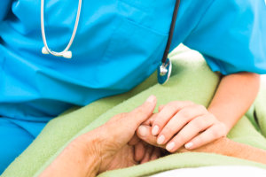 caregiver holding the elderly patient's hands